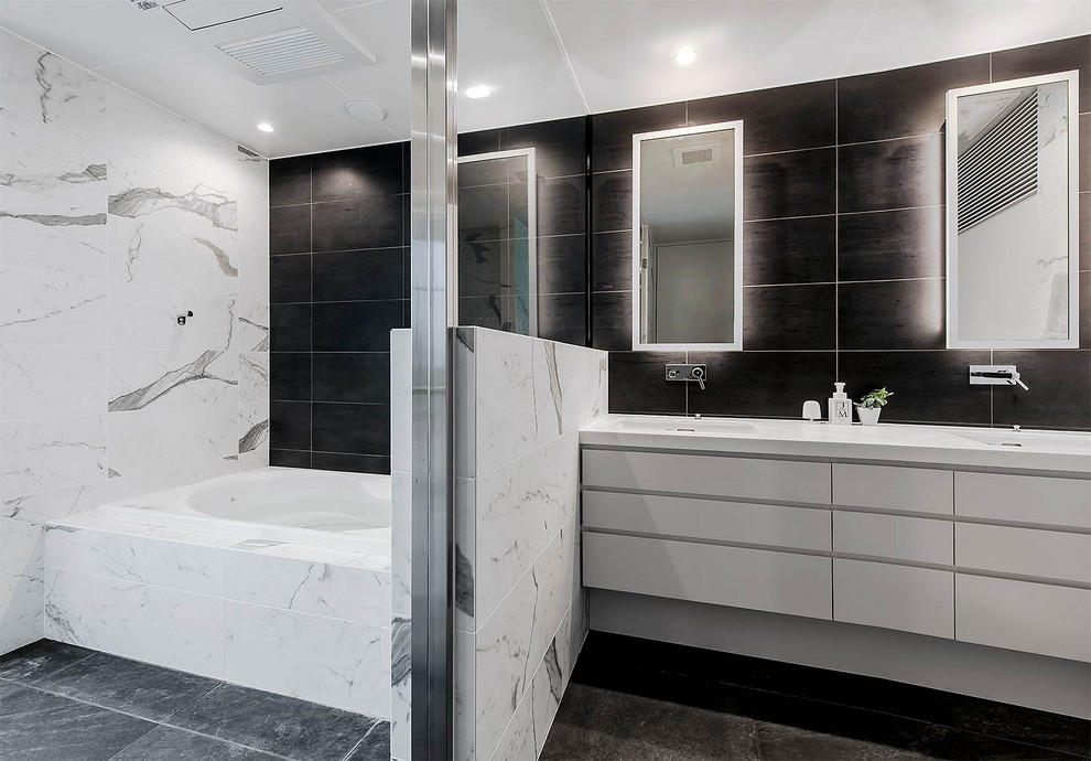 Idées déco pour une salle de bain principale éclectique avec des portes de placard blanches, une baignoire posée, un espace douche bain, un carrelage multicolore, un mur multicolore, un lavabo encastré, un sol gris et un plan de toilette blanc.