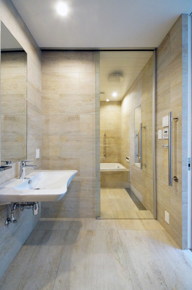 Esempio di una stanza da bagno design con vasca ad angolo, piastrelle beige, pareti beige, pavimento beige e porta doccia scorrevole