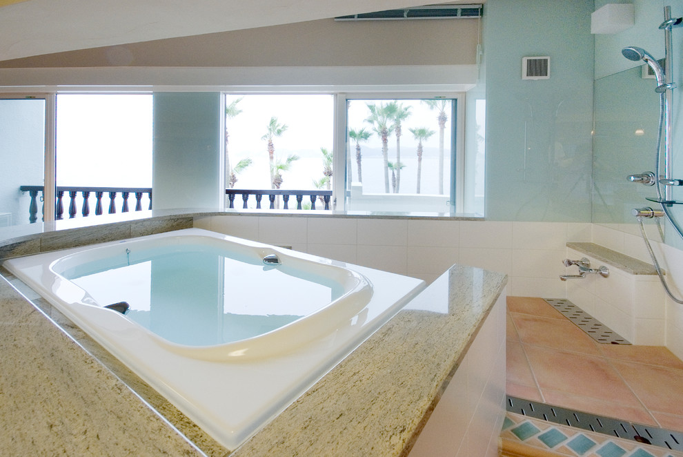 他の地域にある地中海スタイルのおしゃれな浴室 (青い壁、トラバーチンの床、オレンジの床、置き型浴槽、オープン型シャワー、オープンシャワー) の写真