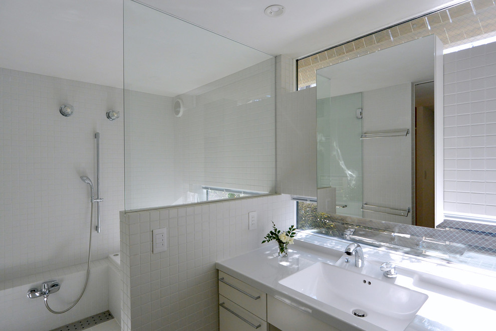 Immagine di una stanza da bagno padronale contemporanea con ante lisce, ante bianche, vasca ad alcova, piastrelle bianche, pareti bianche, lavabo integrato e doccia aperta