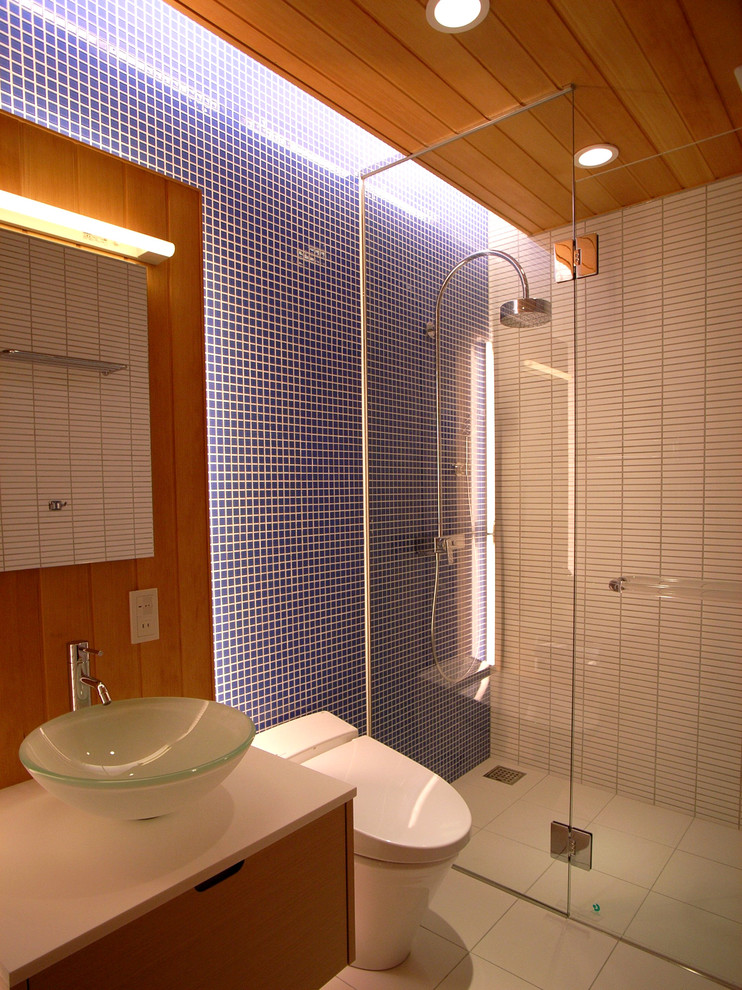 Medium sized contemporary shower room bathroom in Other with white cabinets, a double shower, blue tiles, glass tiles, white walls, ceramic flooring, a vessel sink, solid surface worktops, white floors, white worktops and flat-panel cabinets.