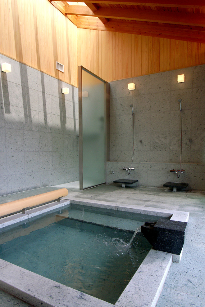 Idee per una grande stanza da bagno padronale industriale con vasca idromassaggio, zona vasca/doccia separata, piastrelle in pietra, doccia aperta, piastrelle grigie, pareti grigie e pavimento grigio