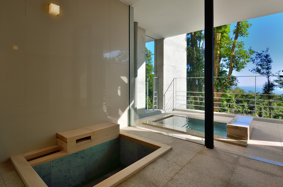 Modern inredning av ett badrum, med ett japanskt badkar, vita väggar och beige kakel