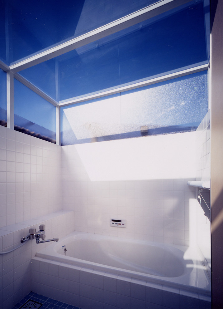 На фото: маленькая главная ванная комната в восточном стиле с фасадами с декоративным кантом, белыми фасадами, гидромассажной ванной, душем над ванной, белой плиткой, керамической плиткой, белыми стенами, полом из керамической плитки, врезной раковиной, столешницей из дерева, синим полом, открытым душем и коричневой столешницей для на участке и в саду с