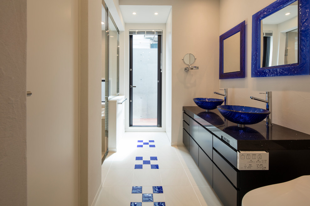 高級な中くらいなコンテンポラリースタイルのおしゃれな浴室 (インセット扉のキャビネット、黒いキャビネット、白いタイル、白い壁、セラミックタイルの床、ベッセル式洗面器、クオーツストーンの洗面台、青い床) の写真