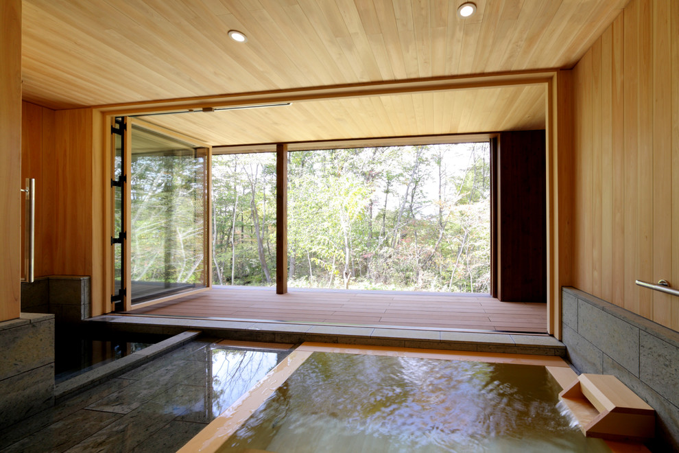 Diseño de cuarto de baño principal asiático grande con bañera japonesa, baldosas y/o azulejos grises, baldosas y/o azulejos de piedra, paredes beige, suelo de baldosas de porcelana y suelo gris