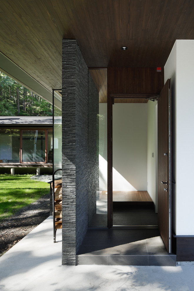 他の地域にあるトラディショナルスタイルのおしゃれな玄関ドア (マルチカラーの壁、セラミックタイルの床、濃色木目調のドア、グレーの床) の写真