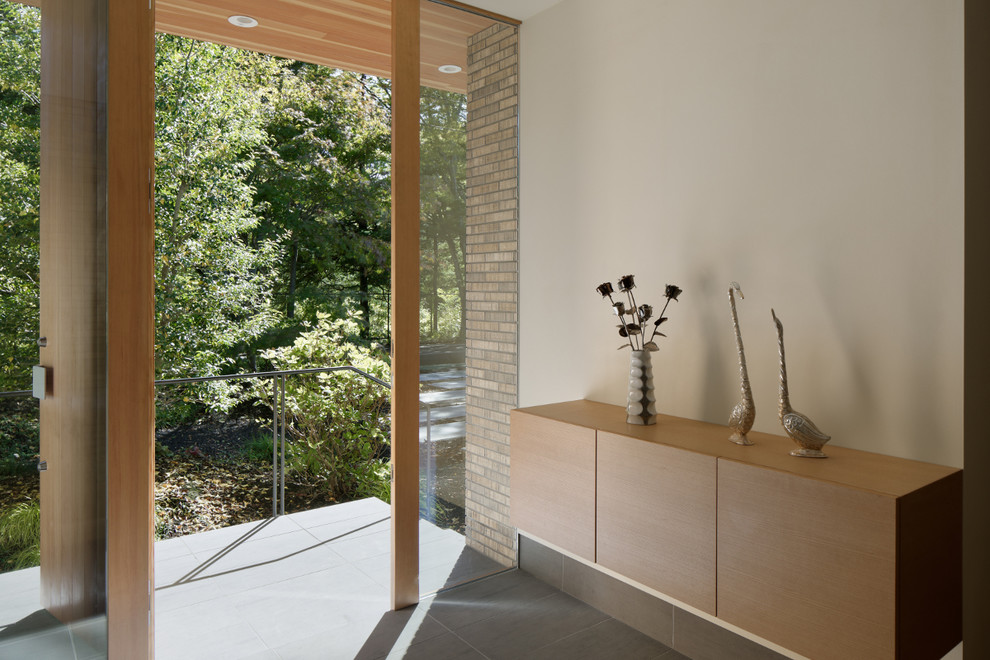 Klassische Haustür mit beiger Wandfarbe, Keramikboden, Einzeltür, heller Holzhaustür und grauem Boden in Sonstige