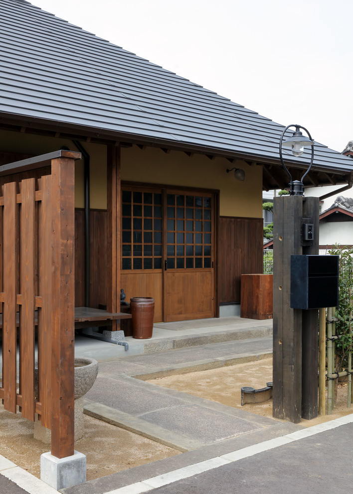 Ejemplo de entrada asiática con paredes beige, puerta corredera y puerta de madera oscura