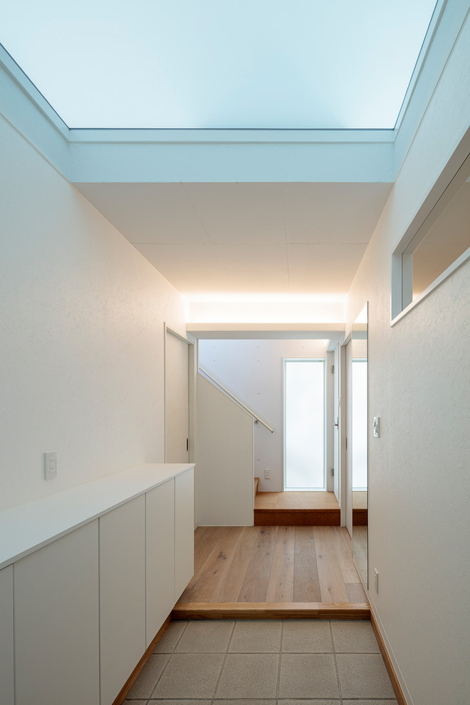 Ispirazione per un corridoio minimalista di medie dimensioni con pareti bianche, pavimento in gres porcellanato e pavimento verde