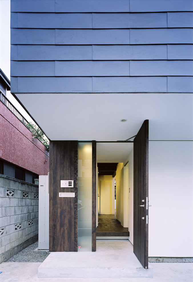 Modelo de puerta principal moderna con paredes blancas, suelo de cemento, puerta simple, puerta marrón y suelo gris