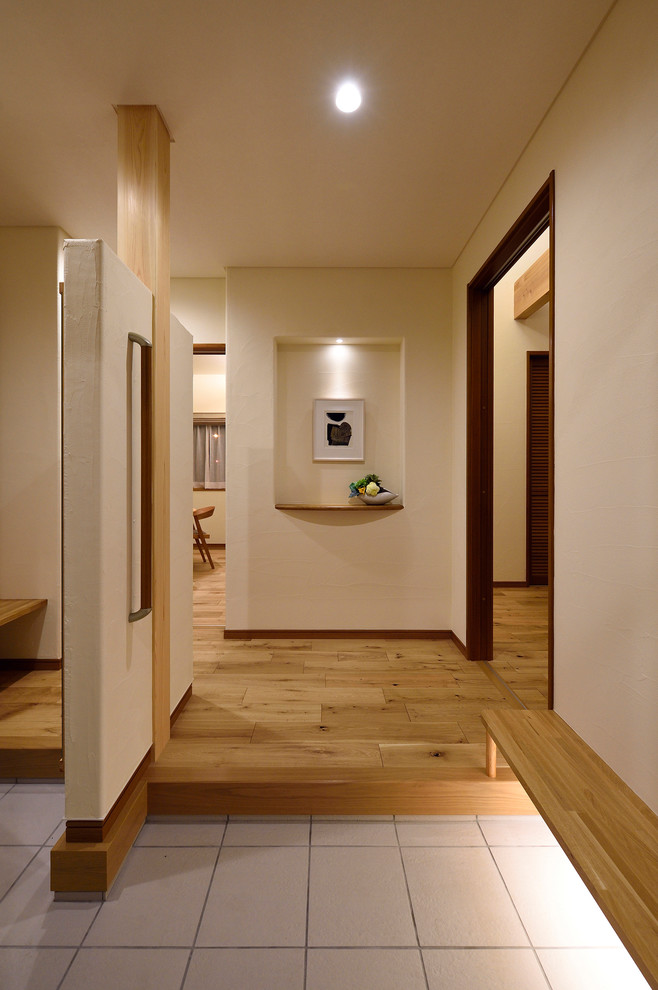 Ejemplo de hall retro de tamaño medio con paredes blancas, suelo de madera en tonos medios, puerta simple y puerta de madera oscura