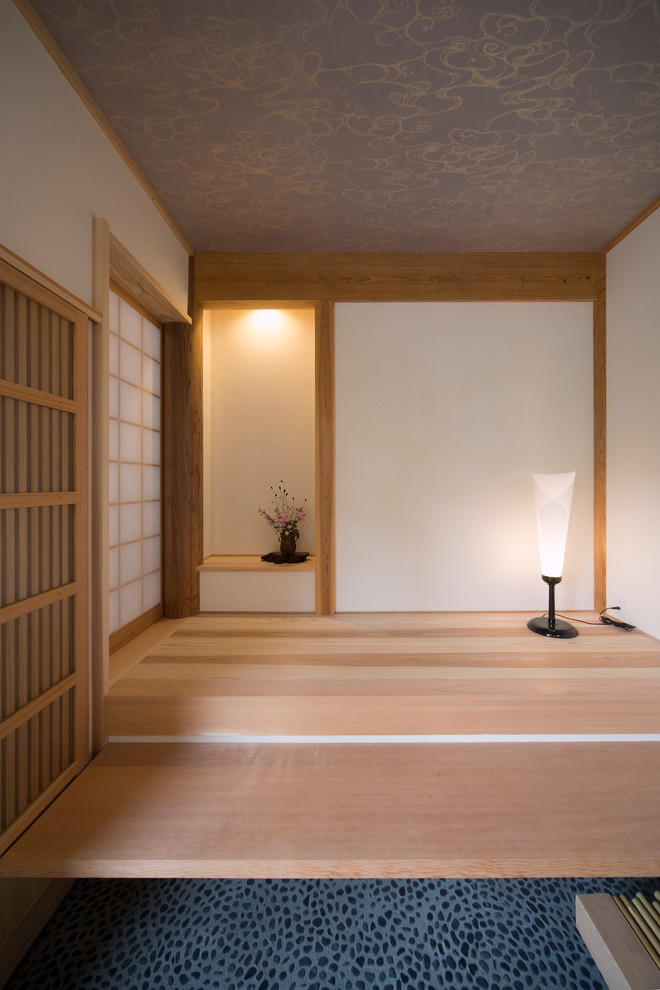 Modelo de sala de estar asiática grande con paredes blancas, suelo de madera clara y suelo beige