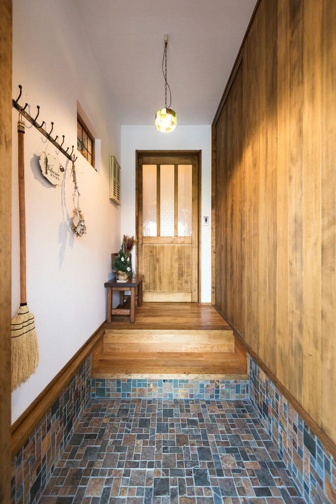 Cette photo montre une entrée asiatique avec un mur blanc, parquet foncé, une porte simple, une porte en bois foncé et un sol multicolore.