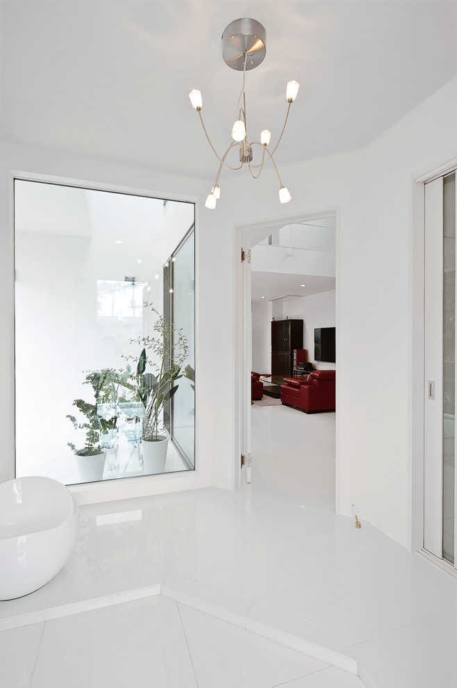 Idée de décoration pour une grande entrée minimaliste avec un couloir, un mur blanc, un sol en carrelage de céramique, un sol blanc, un plafond en papier peint et du papier peint.