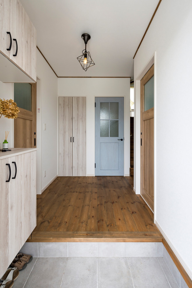 Shabby-Chic Eingang mit Korridor, weißer Wandfarbe, dunklem Holzboden, Einzeltür, weißer Haustür und braunem Boden in Sonstige