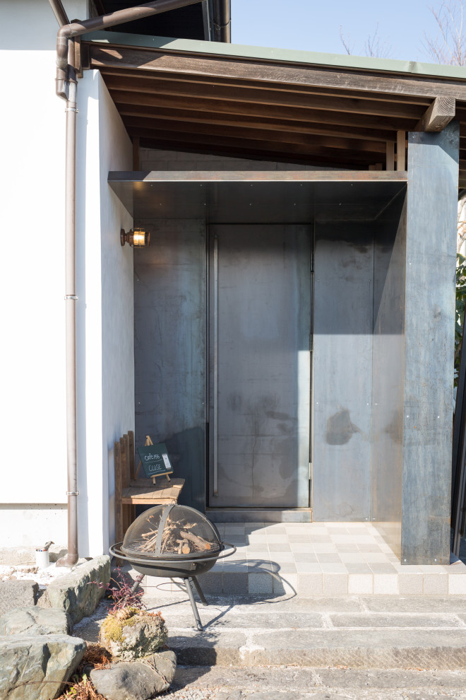 Cette photo montre une petite porte d'entrée industrielle avec un mur blanc, un sol en carrelage de porcelaine, une porte simple, une porte noire, un sol blanc, poutres apparentes et du lambris.