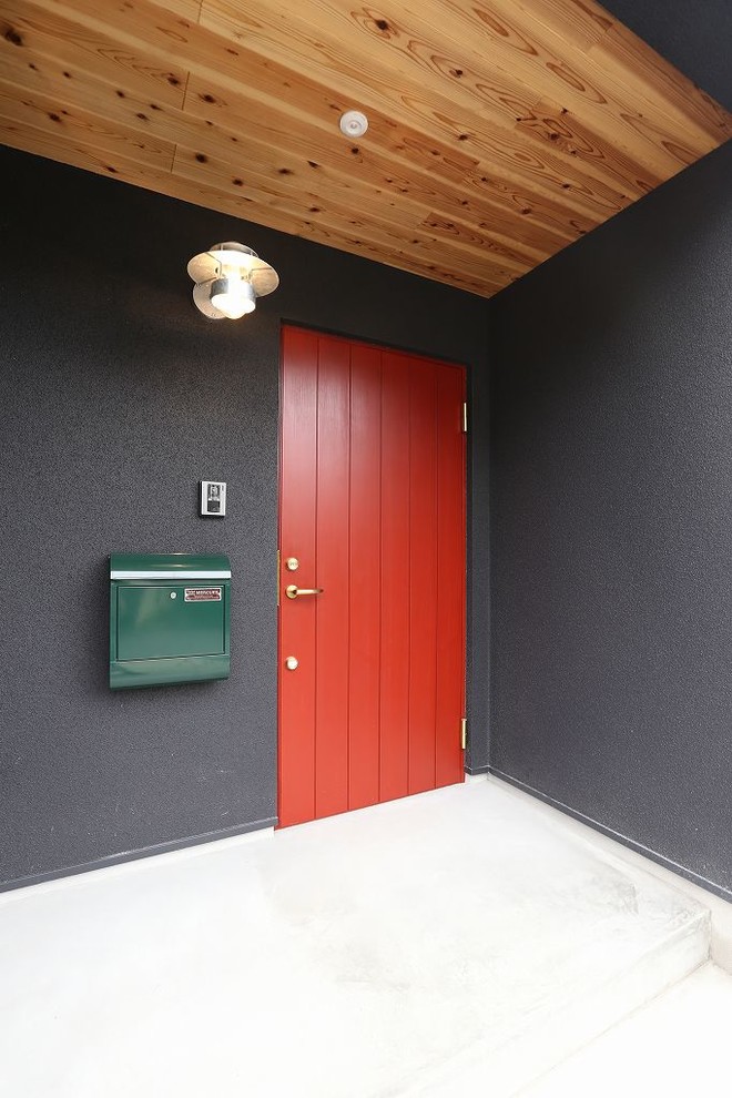 Inspiration for a zen ceramic tile entryway remodel in Other with black walls and a red front door