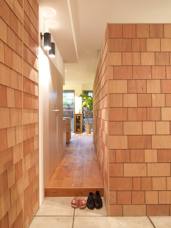 Mittelgroßer Eingang mit Vestibül, brauner Wandfarbe und Betonboden in Tokio
