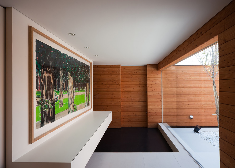 Foto på en funkis entré, med vita väggar, en enkeldörr och mellanmörk trädörr