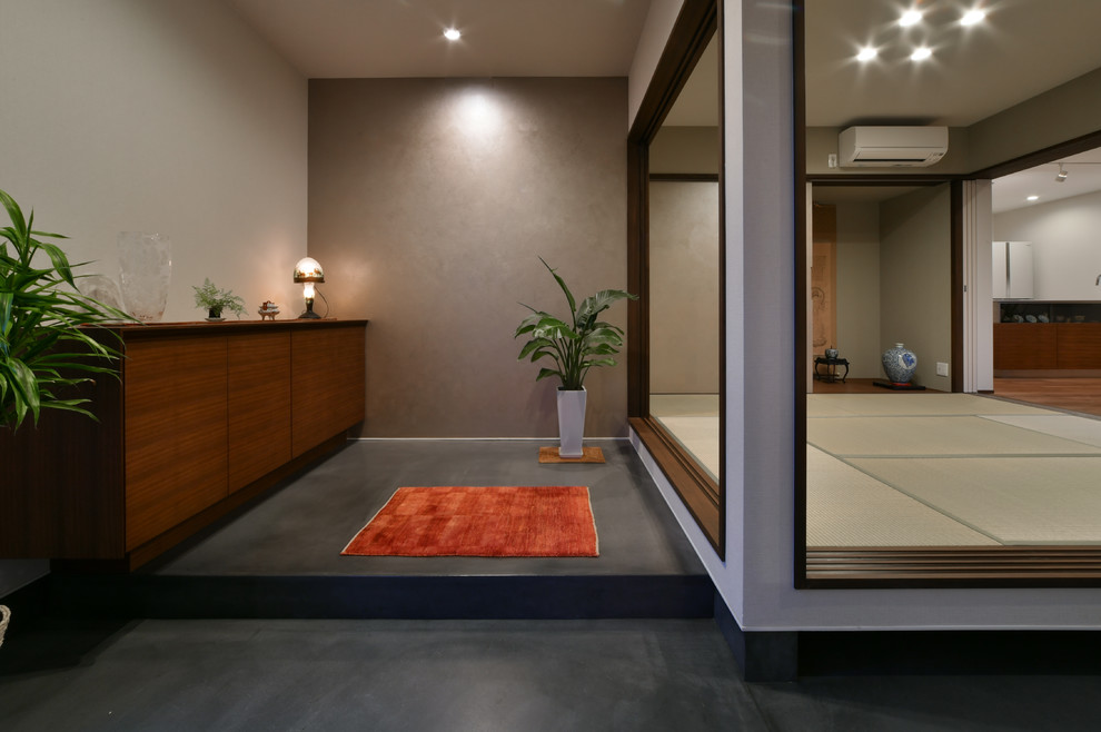 Ejemplo de entrada asiática con paredes blancas, tatami y suelo gris