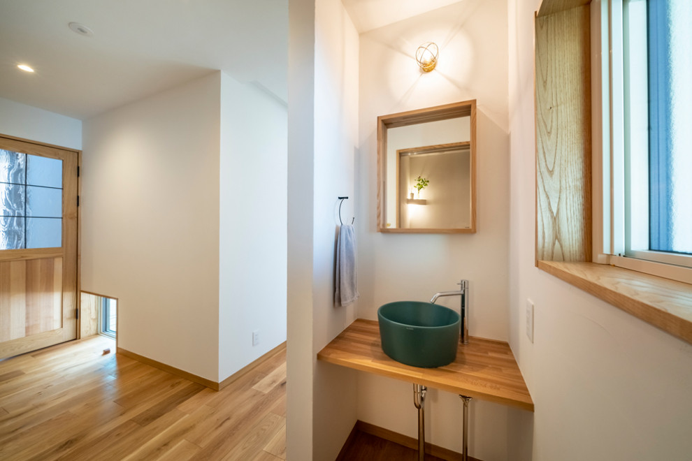 Imagen de hall contemporáneo de tamaño medio con paredes blancas, suelo de madera en tonos medios, puerta simple, puerta de madera en tonos medios y suelo beige
