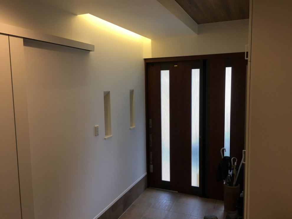 Пример оригинального дизайна: узкая прихожая среднего размера в стиле ретро с белыми стенами, полом из терракотовой плитки, раздвижной входной дверью, входной дверью из темного дерева, бежевым полом, деревянным потолком и обоями на стенах