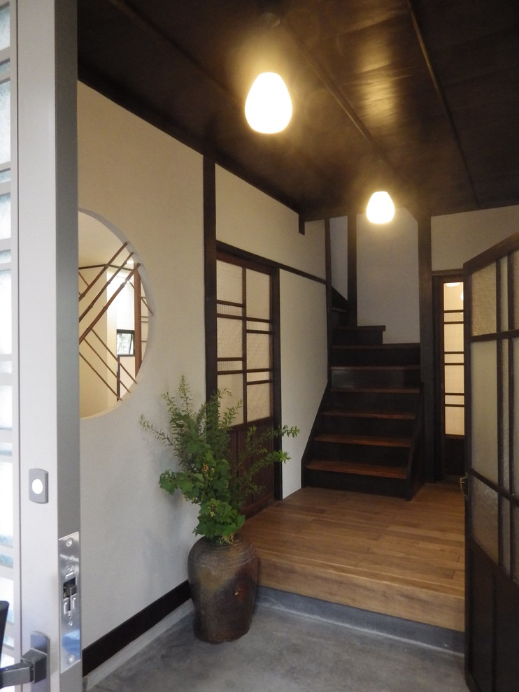 他の地域にある小さな和風のおしゃれな玄関ホール (グレーの壁、無垢フローリング、茶色いドア、茶色い床) の写真