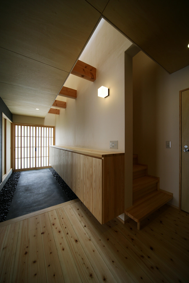Foto de entrada de estilo zen con paredes blancas, puerta corredera y puerta de madera clara