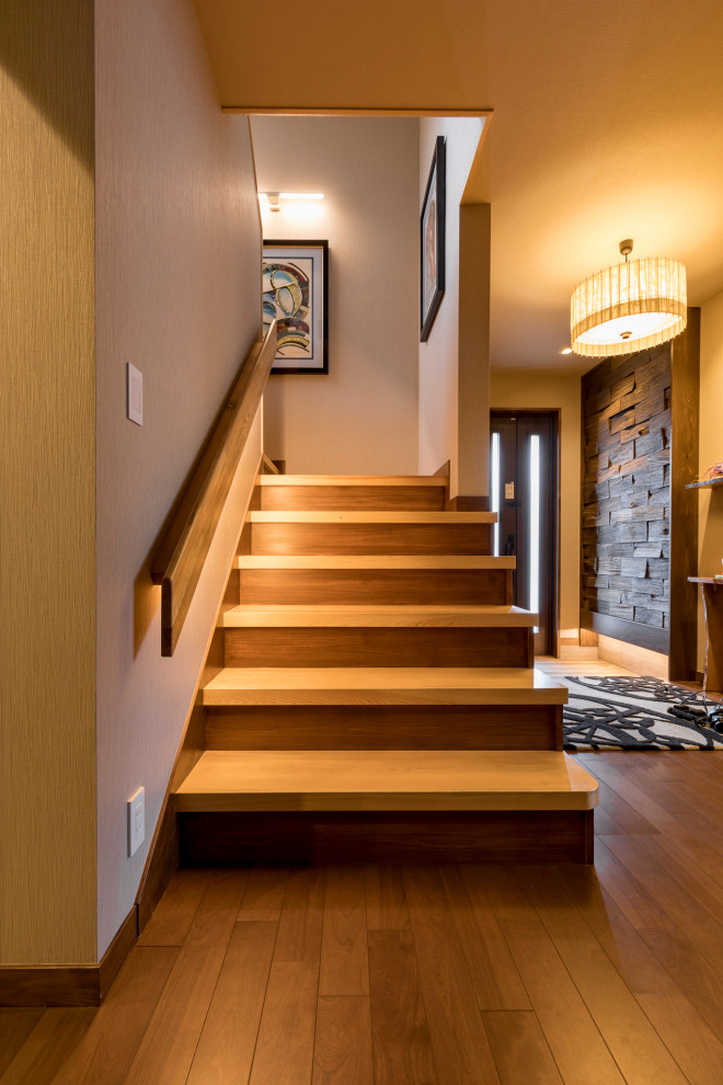 他の地域にある低価格の小さなコンテンポラリースタイルのおしゃれな階段 (木の蹴込み板、木材の手すり) の写真