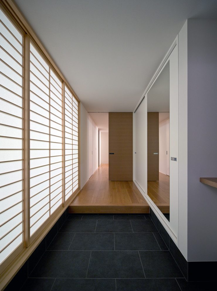 福岡にある和モダンなおしゃれな玄関ホール (白い壁、黒い床) の写真