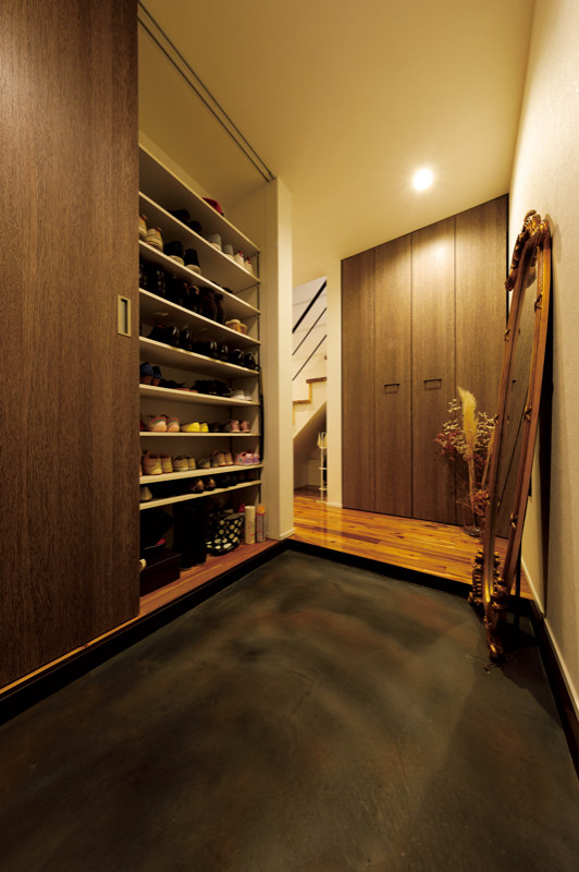 This is an example of a small modern boot room in Tokyo with beige walls, concrete flooring, a single front door, a dark wood front door, grey floors, a wallpapered ceiling and wallpapered walls.