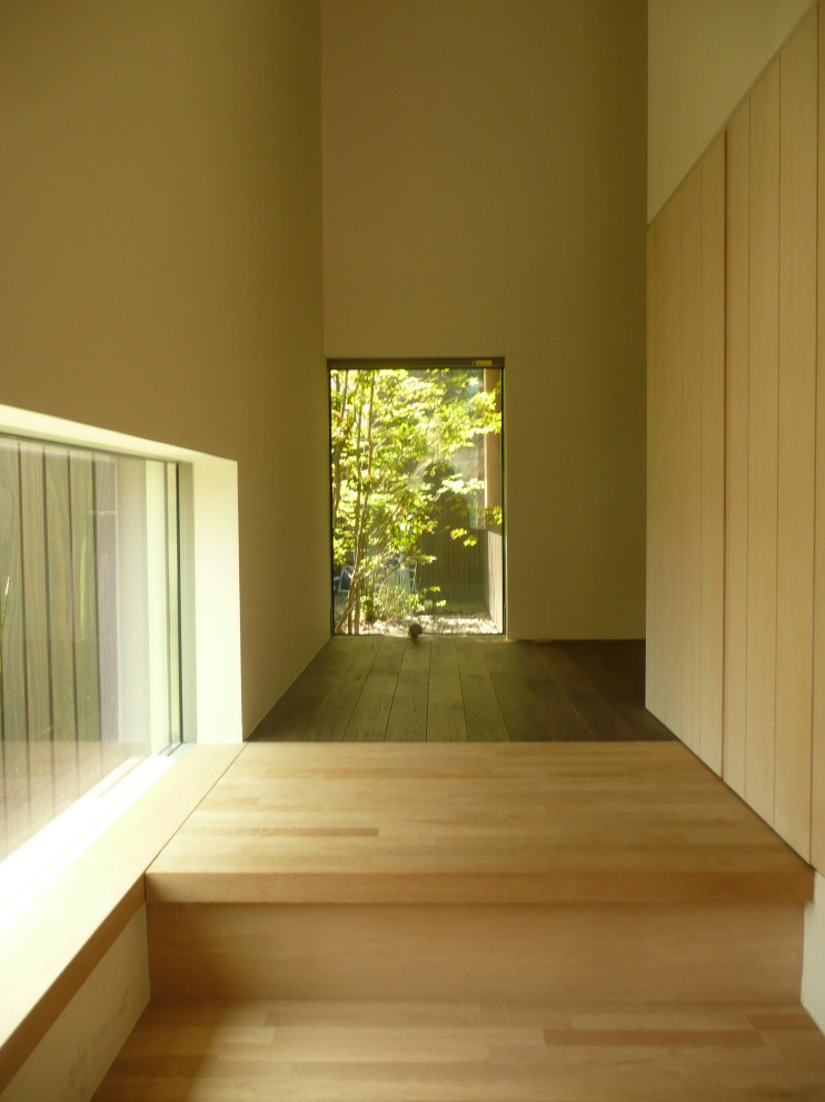 Стильный дизайн: маленькая прихожая в стиле ретро с белыми стенами, темным паркетным полом, коричневой входной дверью и коричневым полом для на участке и в саду - последний тренд