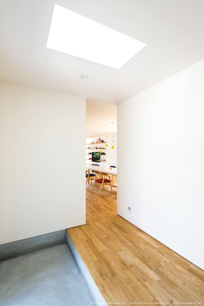 Mittelgroßer Eingang mit Korridor, weißer Wandfarbe, braunem Holzboden, Einzeltür, Haustür aus Metall und braunem Boden in Sonstige