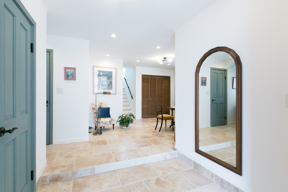 Medelhavsstil inredning av en entré, med marmorgolv, en enkeldörr, en blå dörr och beiget golv