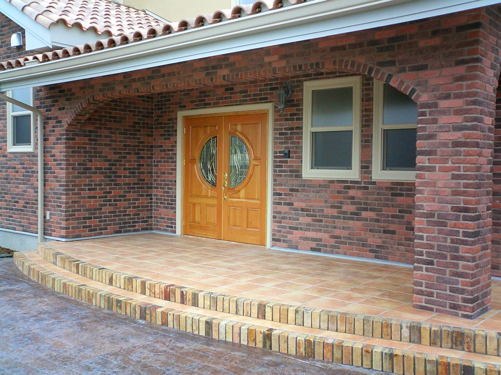 Idée de décoration pour une porte d'entrée design avec un mur marron, tomettes au sol, une porte double, une porte en bois brun et un sol marron.