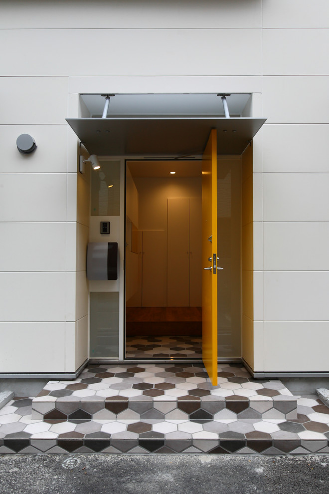 Ejemplo de puerta principal minimalista de tamaño medio con paredes blancas, suelo de baldosas de cerámica, puerta simple, puerta amarilla y suelo multicolor