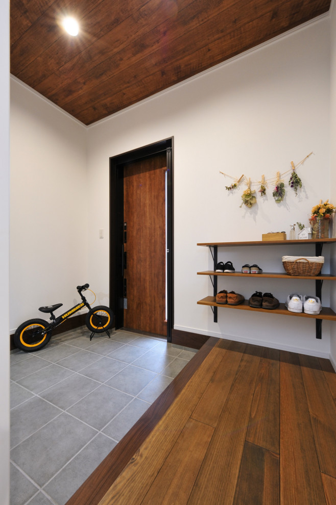 Идея дизайна: прихожая со шкафом для обуви в стиле модернизм с белыми стенами, поворотной входной дверью и входной дверью из темного дерева