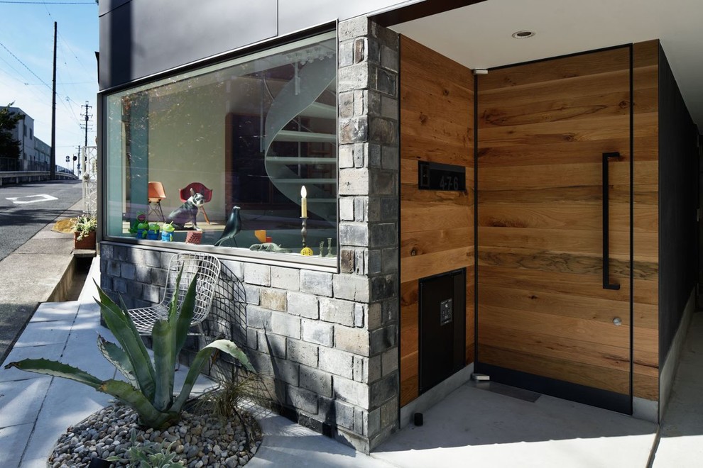Ispirazione per una porta d'ingresso moderna con pareti grigie, una porta singola e una porta in legno bruno