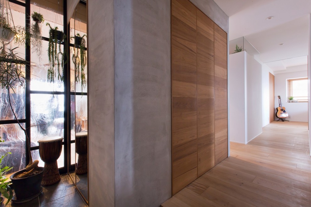 Mittelgroßer Uriger Eingang mit Korridor, weißer Wandfarbe, braunem Holzboden, Einzeltür, Haustür aus Metall und beigem Boden in Sonstige