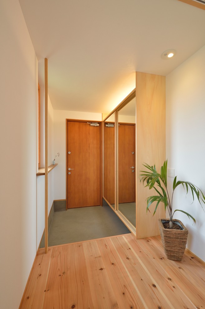 Ispirazione per un corridoio etnico con pareti bianche, una porta singola e una porta in legno bruno