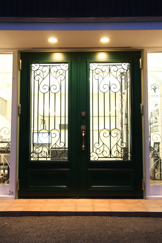 他の地域にあるインダストリアルスタイルのおしゃれな玄関ドア (緑のドア) の写真