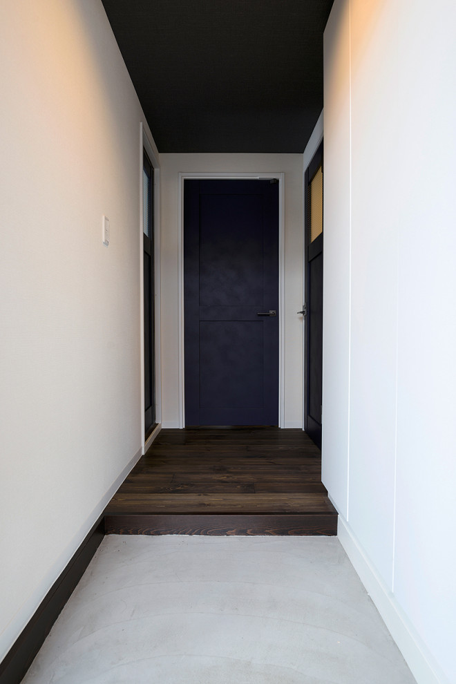Пример оригинального дизайна: узкая прихожая в стиле рустика с белыми стенами, темным паркетным полом, одностворчатой входной дверью, коричневой входной дверью, потолком с обоями и обоями на стенах