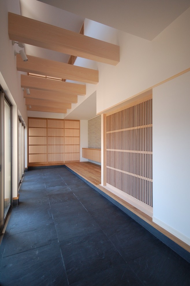 名古屋にある広い和風のおしゃれな玄関ホール (白い壁、無垢フローリング、木目調のドア、ベージュの床) の写真