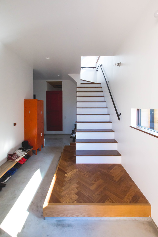 Пример оригинального дизайна: большая прихожая в современном стиле с белыми стенами, бетонным полом, одностворчатой входной дверью, черной входной дверью и серым полом