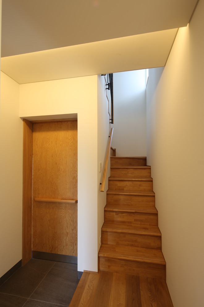 Идея дизайна: маленькая входная дверь в восточном стиле с полом из керамической плитки, одностворчатой входной дверью, входной дверью из светлого дерева, серым полом и белыми стенами для на участке и в саду