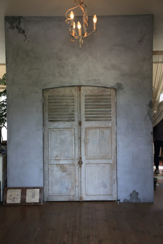 Aménagement d'une entrée romantique avec un mur gris, parquet foncé, une porte double et une porte grise.