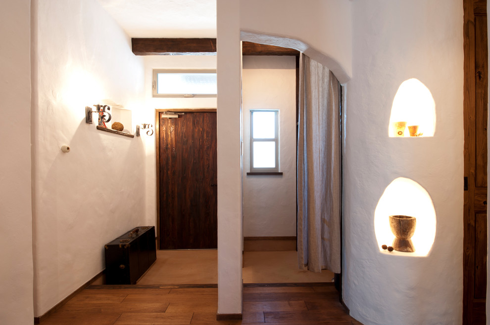 Modelo de hall mediterráneo de tamaño medio con paredes púrpuras, suelo de madera oscura, puerta simple, puerta marrón y suelo marrón