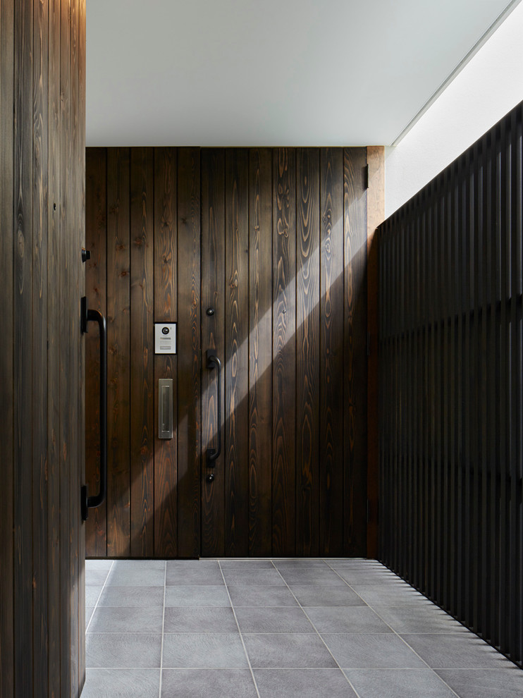Пример оригинального дизайна: прихожая в стиле лофт с коричневыми стенами, одностворчатой входной дверью и входной дверью из темного дерева