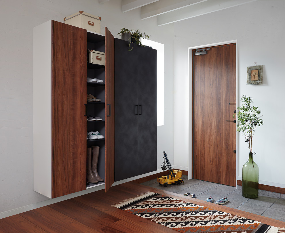 Inspiration for an industrial medium tone wood floor and brown floor single front door remodel in Tokyo with white walls and a medium wood front door